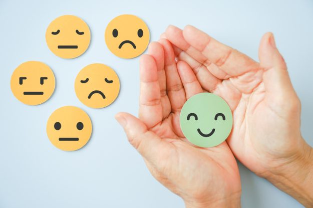 hand holding happy smile face paper cut with other on background, good positive ,customer review feedback rating, experience, mental health assessment, child wellness, world mental health day